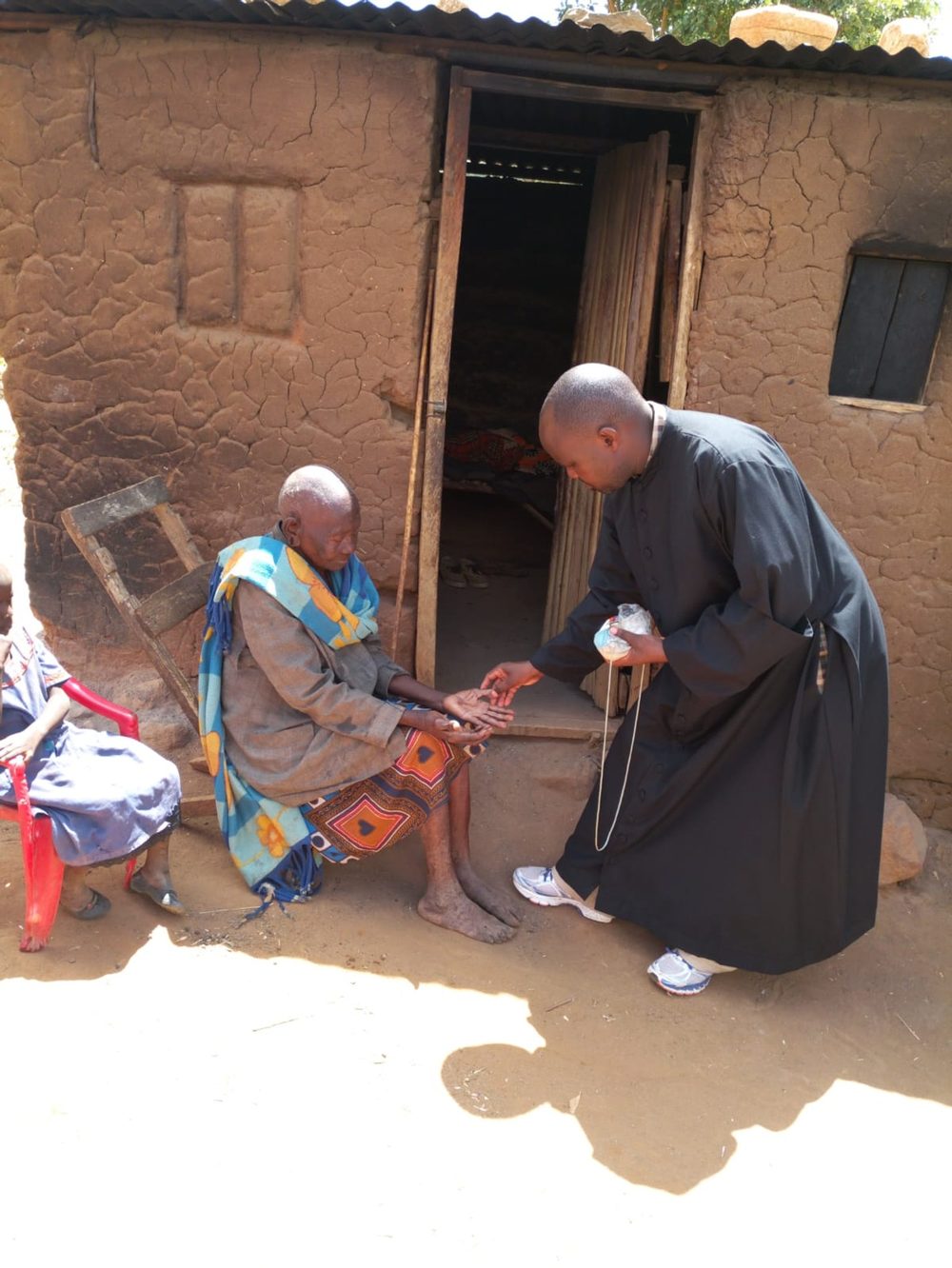 A priest visiting an elderly parishioner at her home
